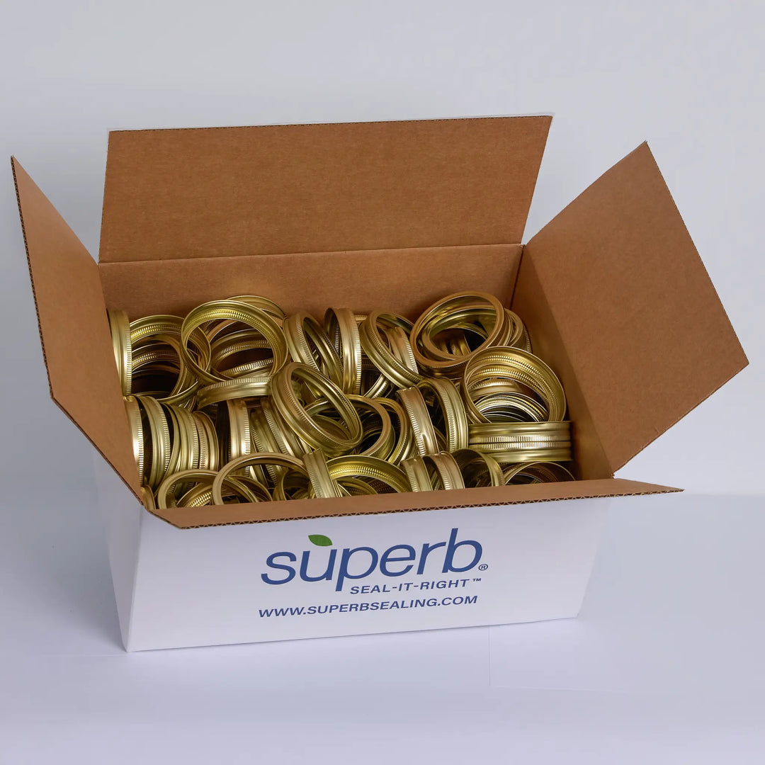 Box of gold canning jar rings with Superb Canning branding on a white background