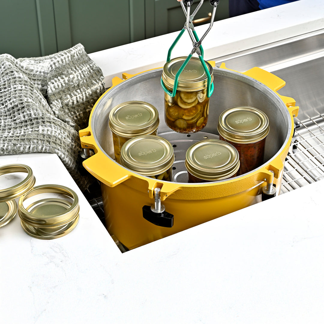 Wide mouth glass canning jar with metal lid from Superb Superb brand wide mouth mason jars stacked neatly High-quality canning jars for food storage Pickled cucumbers sealed in wide mouth jar Soup stored in a Superb regular mouth jar Superb jars supporting sustainable food prep